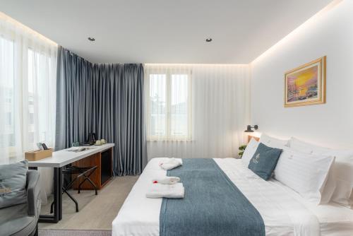 a hotel room with a bed and a desk at Arriba Rooms in Poreč
