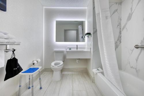 a bathroom with a toilet and a sink and a tub at Best Western Greensboro Coliseum Inn in Greensboro