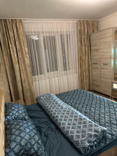 a bedroom with a bed with a blue comforter at Timi&Amos2 in Caransebeş