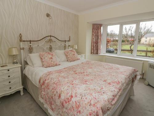 a bedroom with a large bed and a window at Glanyrafon Smithy in Llandysul