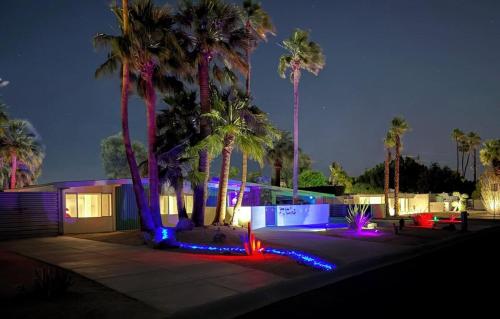 a house with palm trees and lights at night at Retro A Go Go House in Palm Springs
