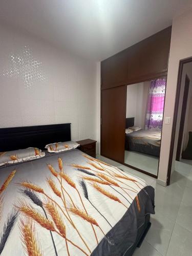 a bedroom with a large bed and a mirror at Departamento 1 centro de la ciudad in Santo Domingo de los Colorados