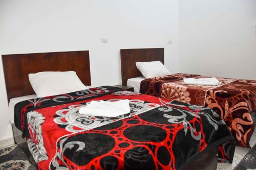 two beds sitting next to each other in a room at Amenirdis Villa in Al Qurnah