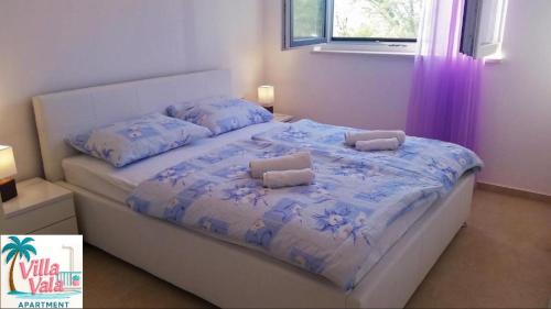 a bed with two pillows on it in a bedroom at Apartment Villa Vala in Malinska