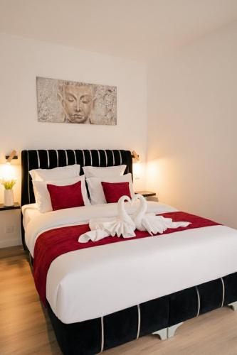 a bedroom with a large bed with red pillows at Le Joyau du lac in Charavines