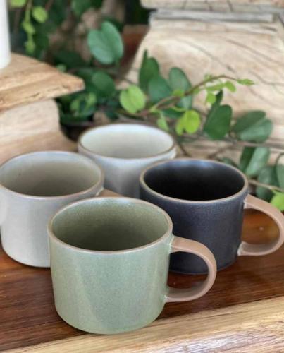 four cups of coffee sitting on a wooden table at Ironbark Villa 2 in Halls Gap