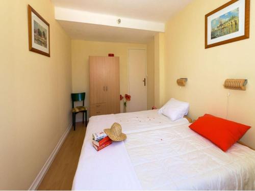 a bedroom with a large white bed with a hat on it at Gîte Guillaume with swimming pool in Carcès