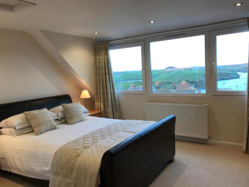 a bedroom with a large bed and large windows at Firm Anchor in Salcombe