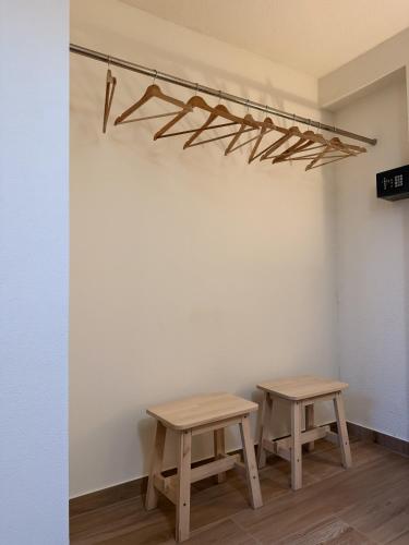 two wooden benches in a room with a wall with a shelf at Piedade Guest House - Lisbon South by Rosado in Almada