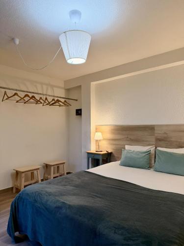 a bedroom with a large bed with a blue blanket at Piedade Guest House - Lisbon South by Rosado in Almada