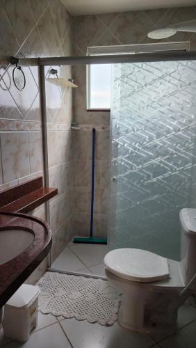 a bathroom with a toilet and a glass shower at Apt Vista para o Mar in Conde