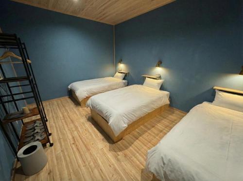 two beds in a room with blue walls at 山過HOTELs in Chino