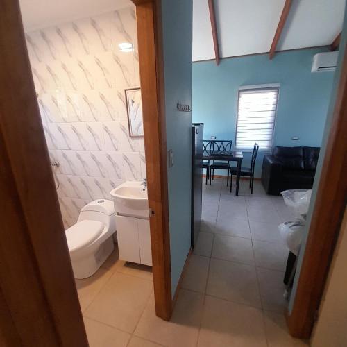 a bathroom with a toilet and a sink and a table at Quillon cabañas in Quillón