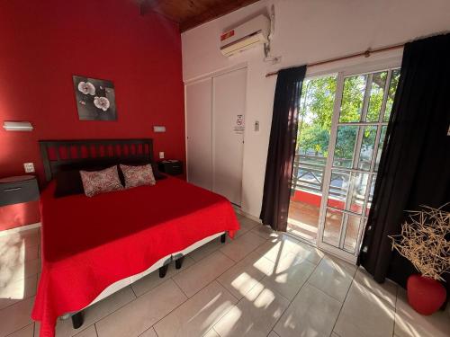 a red bedroom with a bed and a large window at AltoRojo in Villa Elisa