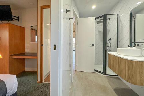 a bathroom with a sink and a shower and a bathroom with a toilet at All Seasons Mildura Holiday Park in Mildura