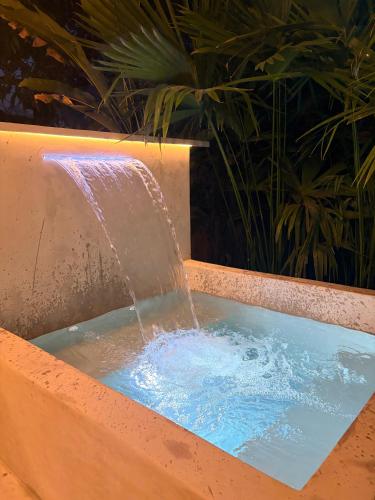 a water fountain in a tub with blue water at Cabaña in Sopetrán