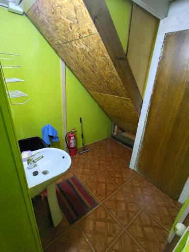 a bathroom with a sink and a green wall at Los Tatas in Colbún