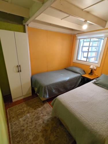 a small room with two beds and a window at Los Tatas in Colbún