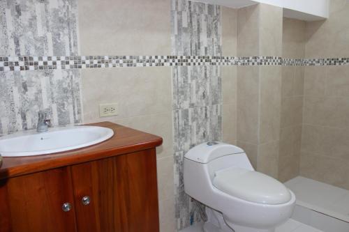 a bathroom with a toilet and a sink at The Island Home in Puerto Ayora
