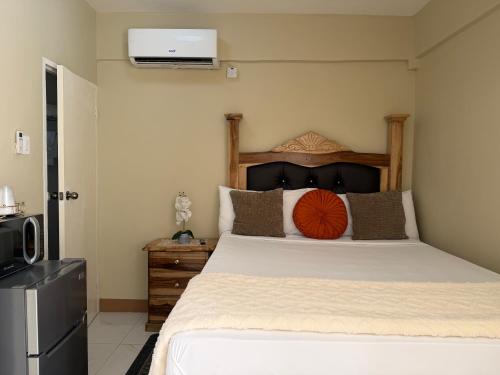 a bedroom with a large bed with a wooden headboard at 1 BR Love Cube in Kingston