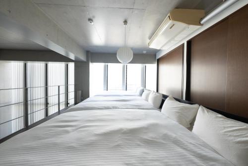 a long bed in a room with windows at ARTK'SJosui in Fukuoka