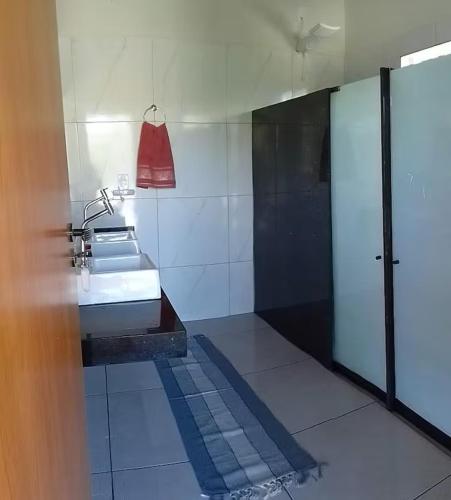 a bathroom with a sink and a red purse at Glampiri in Pirenópolis