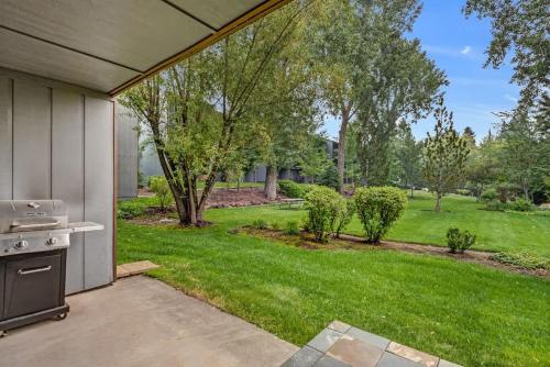 a backyard with an outdoor kitchen and a lawn at First-Floor Downtown Bend Condo in Bend