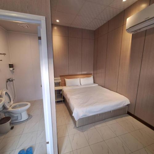 a small bedroom with a bed and a toilet at Nanwan Muyang 168 Homestay in Hengchun South Gate