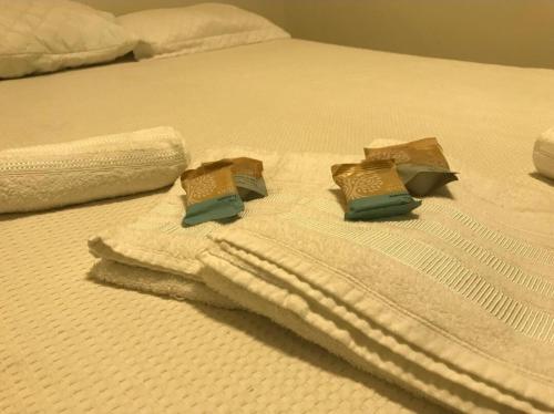 a white bed with towels and pillows on it at Apto completo próximo a Johnson e Johnson e Dutra in São José dos Campos