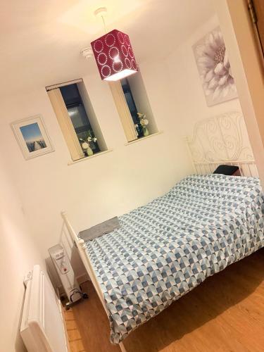 a bedroom with a bed and two windows at Quick Stop Double Bed Flat - Bradford City Center in Bradford