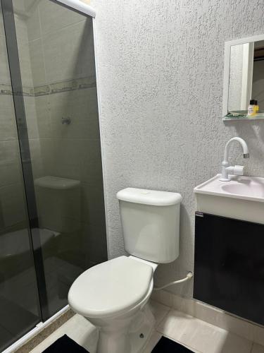 a bathroom with a toilet and a shower and a sink at Vivendas do Paiol in Guapimirim