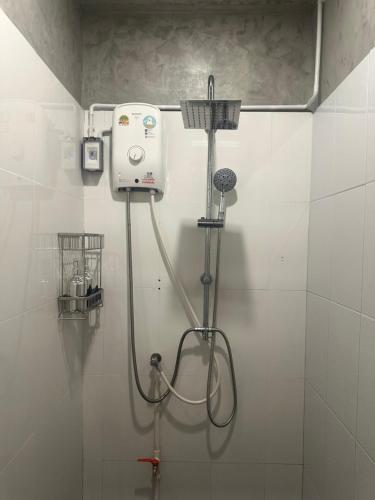 a shower in a white tiled bathroom at Charming Hostel in Bangkok