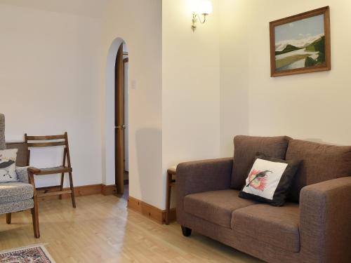 a living room with a couch and a chair at Spey Cottage in Aberlour