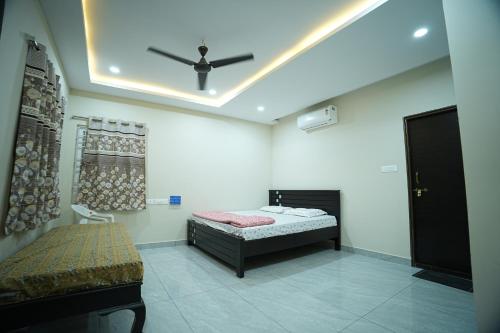 a bedroom with a bed and a ceiling fan at Sri RENUKA VSR Residency in Avanigadda
