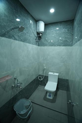 a bathroom with a white toilet and a shower at Sri RENUKA VSR Residency in Avanigadda