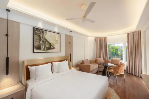 a bedroom with a bed and a living room at Hotel Gwalior Regency, a member of Radisson Individuals in Gwalior