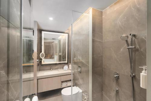 a bathroom with a shower and a toilet and a sink at Hotel Gwalior Regency, a member of Radisson Individuals in Gwalior