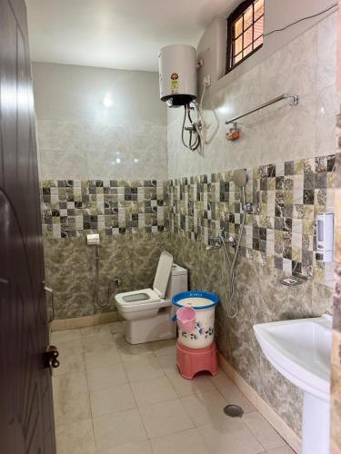 a bathroom with a toilet and a sink at Fun N Forest Resort in Dehradun