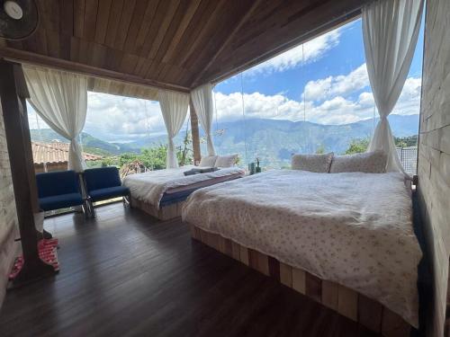 two beds in a room with a large window at Mando Homestay in Bắc Yên