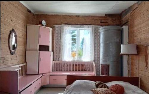 a bedroom with a pink refrigerator and a window at Keltainen talo in Ylivieska
