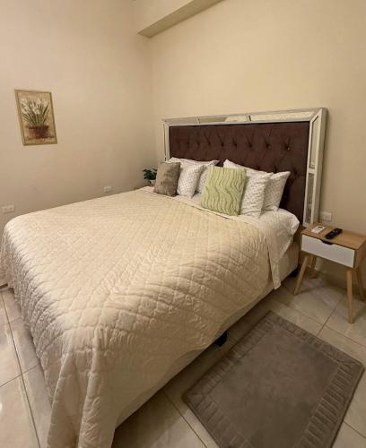 a bedroom with a large bed with a white comforter at Loft Corceles 1, Zona Bonita in Hermosillo