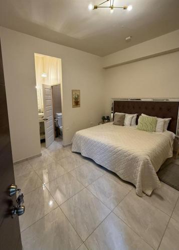 a bedroom with a large bed and a bathroom at Loft Corceles 1, Zona Bonita in Hermosillo