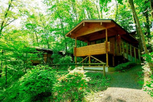 a large wooden cabin in the middle of a forest at PICA Chichibu in Chichibu