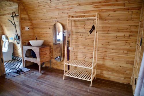 a bathroom with a sink and a wooden wall at Mando Homestay in Bắc Yên