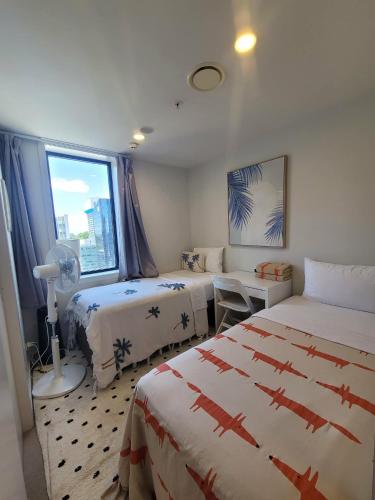 a hotel room with two beds and a window at Sky tower just next DOOR FREE parking in Auckland