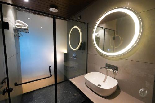 a bathroom with a sink and a mirror at COUNTRYSIDE RESORT MURTi in Chālsa Mahābāri