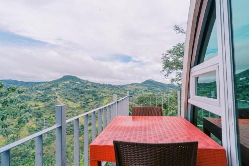 a red table and chairs on a balcony with a view at Serenity Busay Room 8 in Cebu City