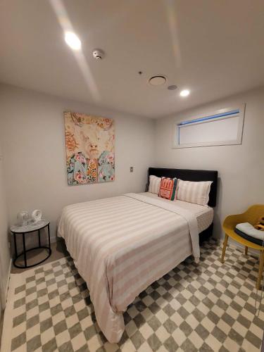 a bedroom with a large bed and a checkered floor at 2Bedrooms,SkyTower next 20 m, FREE parking, Air con in Auckland