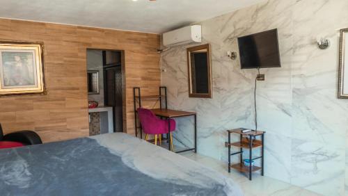 a bedroom with a bed and a tv on a wall at Hotel María Bonita by Chavira in Nuevo Laredo