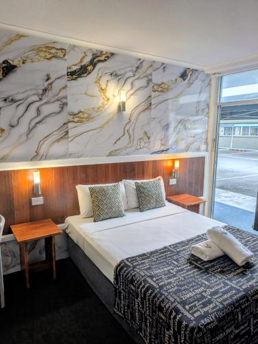 a bedroom with a bed and a wall with a mural at Hampton Villa Motel in Rockhampton